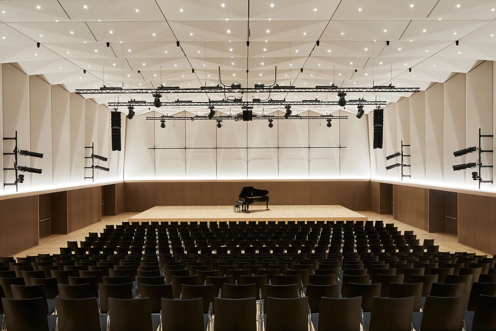 Kulturweberei Finsterwalde, bestuhlter Hauptsaal mit Bühne und Flügel, Licht- und Tontraversen unter der hellen Faltdecke